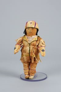 Image of Innu hunter tea doll in hide outfit decorated with beads
